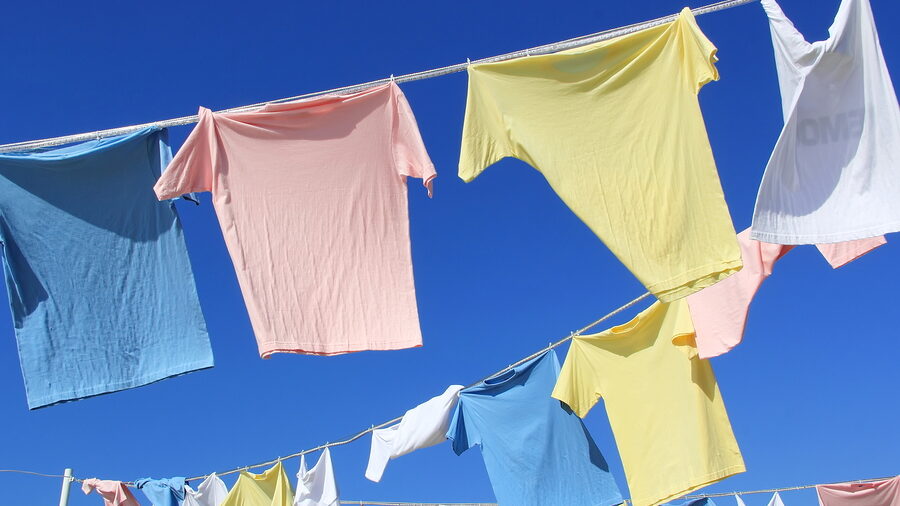 T-shirts Hanging On A Clothesline In Front Of Blue Sky