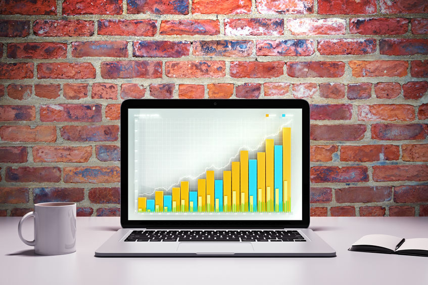 Laptop with business graph on a table with cup of coffee