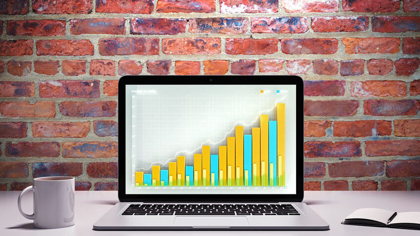Laptop with business graph on a table with cup of coffee
